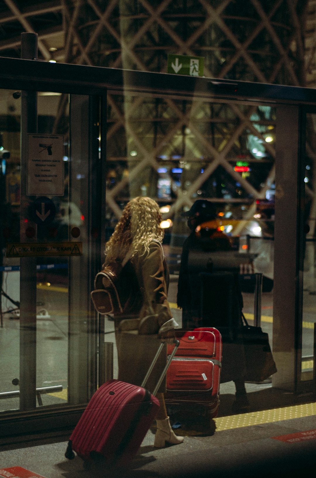Woman walking down a street with a red suitcase